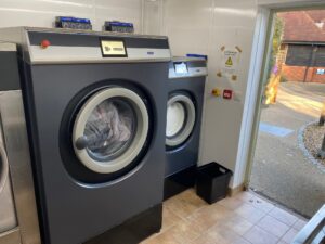 A photo of two grey laundry machines inside a laundry room