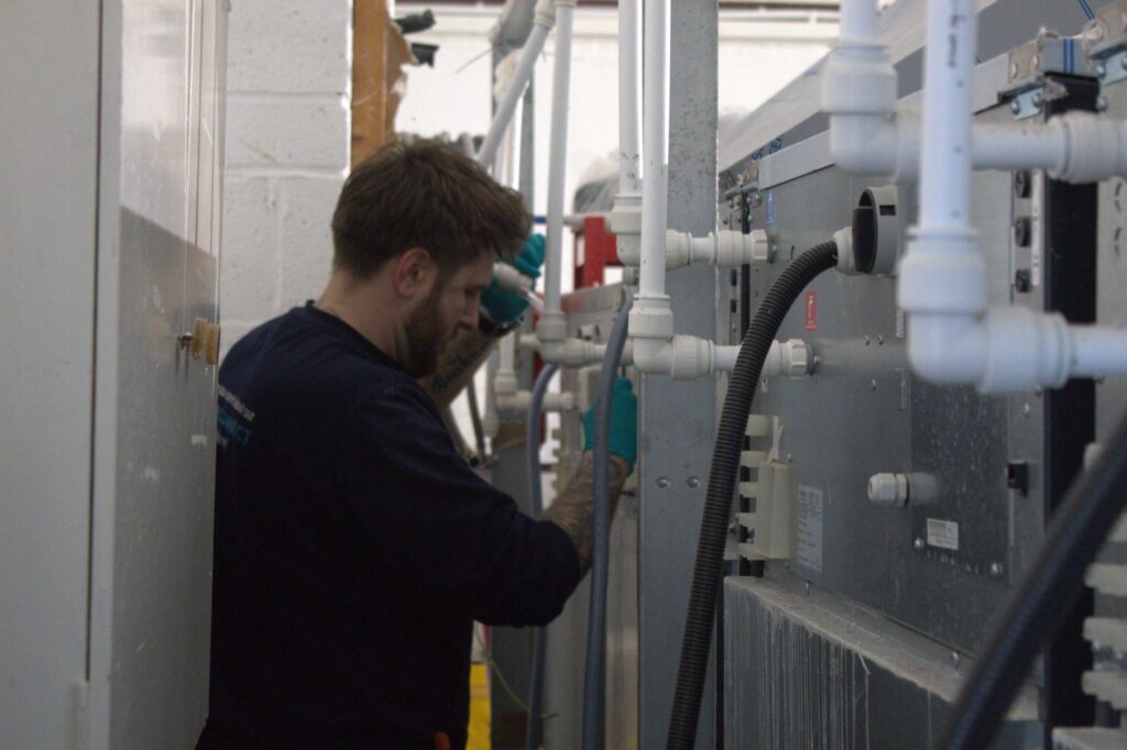 A WASHCO engineer working behind WASHING machines